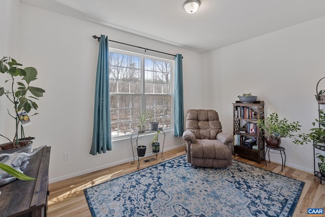 living area featuring baseboards and wood finished floors