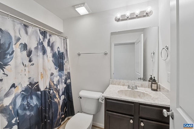 bathroom featuring toilet, a shower with shower curtain, and vanity