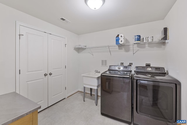 washroom with light floors, visible vents, washing machine and dryer, laundry area, and baseboards