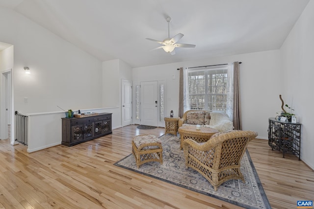 living room with vaulted ceiling, light wood finished floors, a ceiling fan, and baseboards