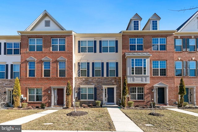 view of property with brick siding and a front lawn