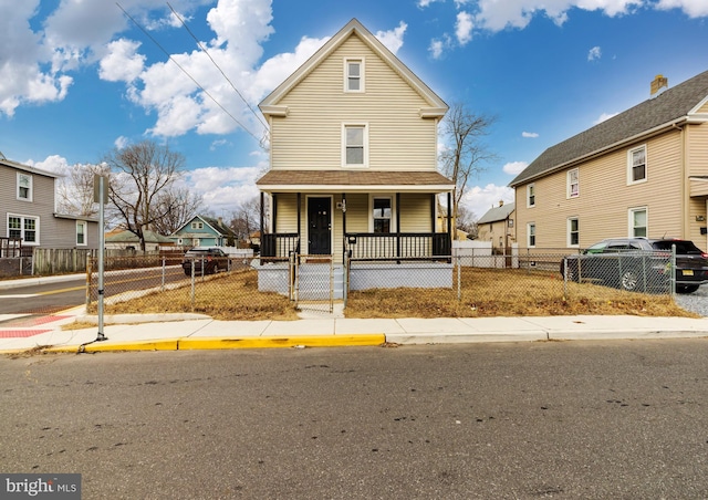 view of front of home with a porch, a fenced front yard, and a residential view