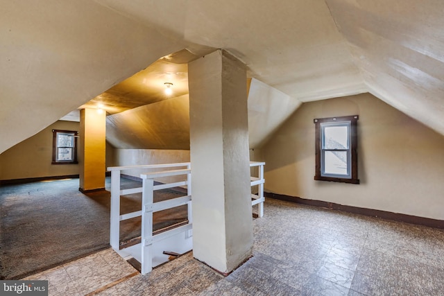 additional living space with vaulted ceiling and baseboards