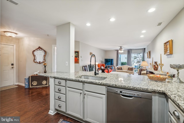 kitchen with visible vents, stainless steel dishwasher, open floor plan, a sink, and light stone countertops