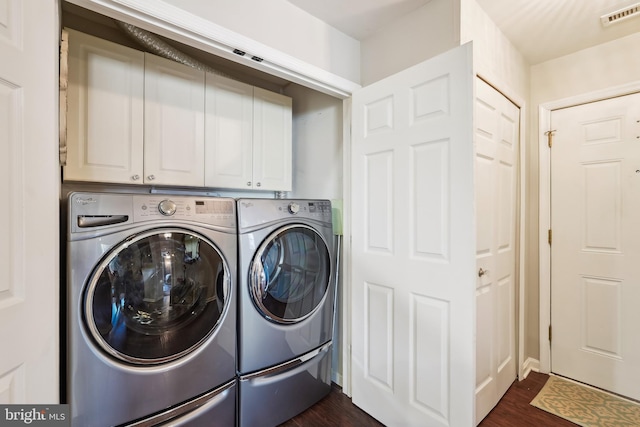 washroom with washing machine and dryer, dark wood-style flooring, visible vents, and cabinet space