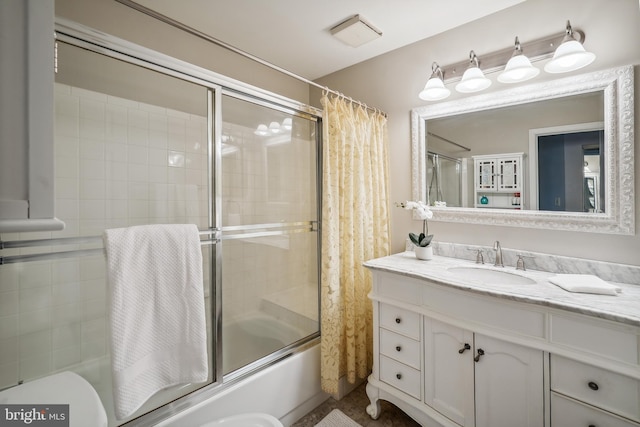 bathroom featuring combined bath / shower with glass door, vanity, and toilet