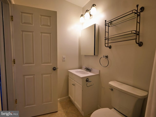 bathroom with toilet, baseboards, vanity, and tile patterned floors