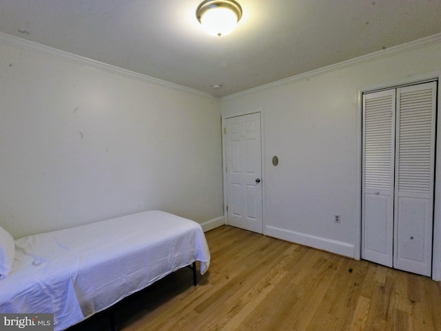 bedroom featuring baseboards, light wood-type flooring, and crown molding