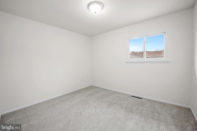 unfurnished room featuring carpet, visible vents, and baseboards