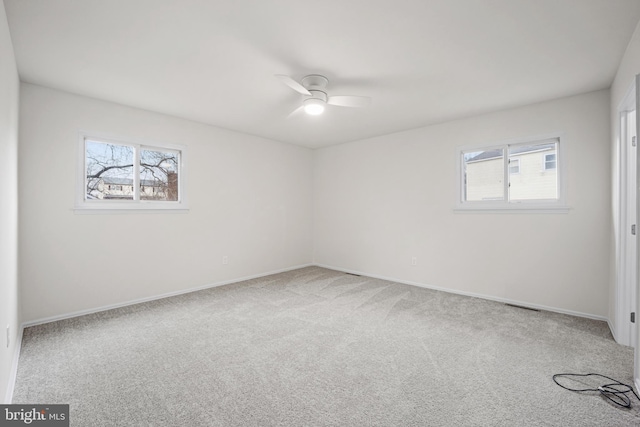 unfurnished room with a ceiling fan, carpet flooring, and baseboards