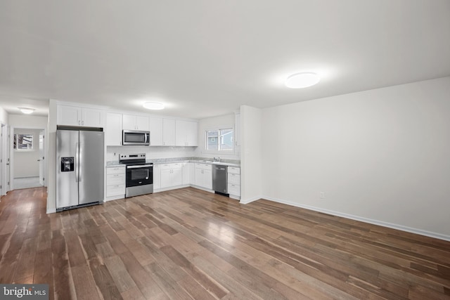 kitchen with dark wood finished floors, appliances with stainless steel finishes, white cabinets, and light countertops