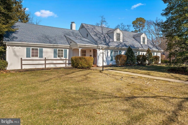 cape cod house featuring a front yard and a chimney