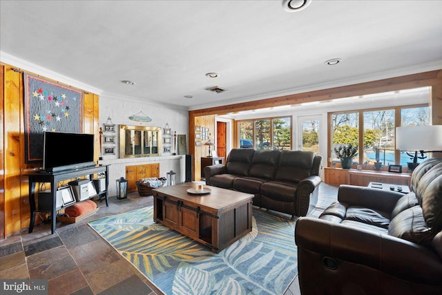 living area featuring stone finish floor, visible vents, crown molding, and recessed lighting