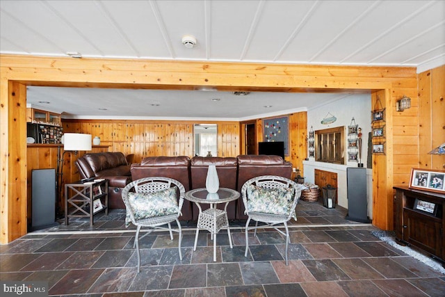 dining room featuring stone finish flooring and wooden walls