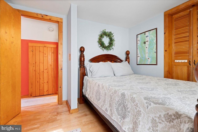 bedroom featuring light wood finished floors and baseboards