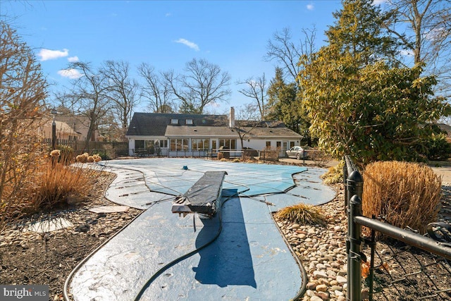 back of property featuring a patio area, fence, and a fenced in pool