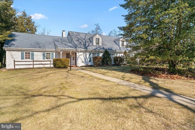 cape cod house with a front yard