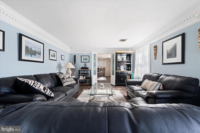 living room featuring wood finished floors, visible vents, and crown molding