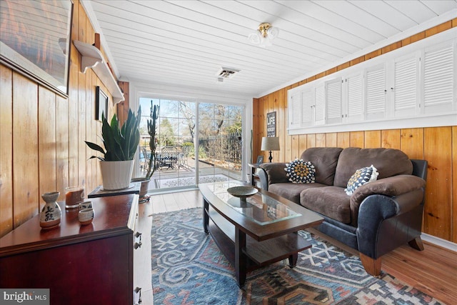 living room featuring wood ceiling, wooden walls, and wood finished floors