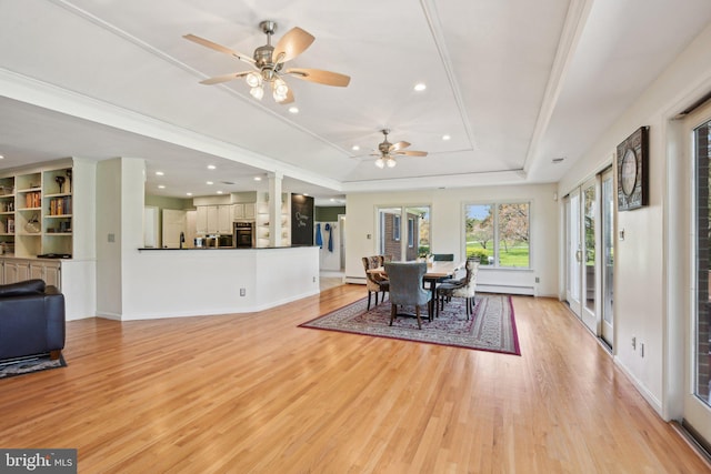 dining space featuring a tray ceiling, recessed lighting, light wood-style floors, and a ceiling fan