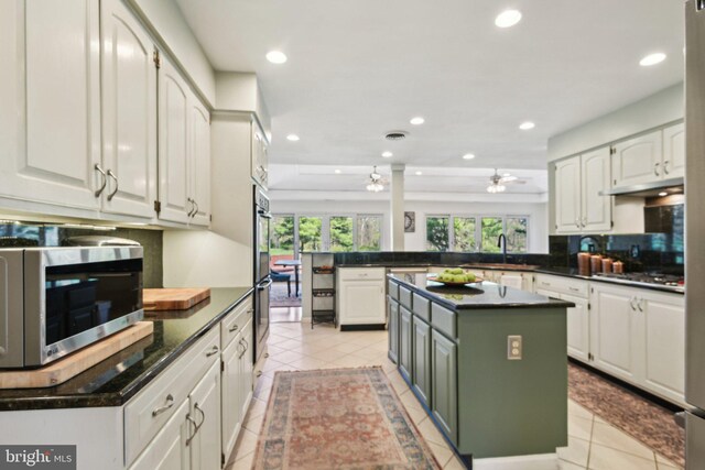 kitchen featuring a sink, light tile patterned flooring, a peninsula, and stainless steel appliances
