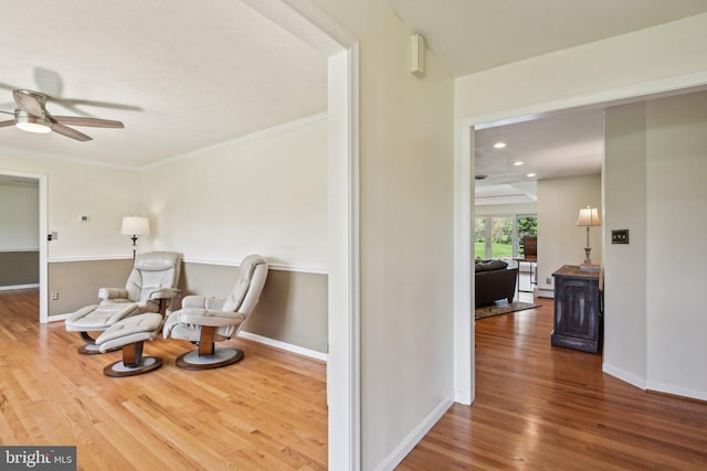 living area featuring baseboards, a ceiling fan, crown molding, recessed lighting, and wood finished floors