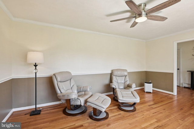 unfurnished room with baseboard heating, ceiling fan, ornamental molding, and wood finished floors