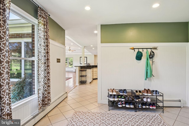 hallway with a baseboard radiator, recessed lighting, and tile patterned flooring