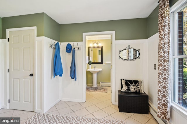 bathroom featuring a baseboard radiator, a baseboard heating unit, a sink, and tile patterned floors