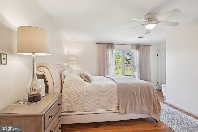 bedroom with wood finished floors, ceiling fan, baseboards, and visible vents