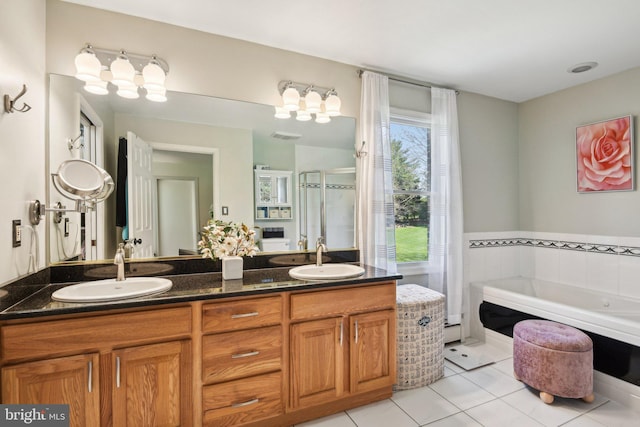 full bath with a shower stall, tile patterned floors, a garden tub, and a sink