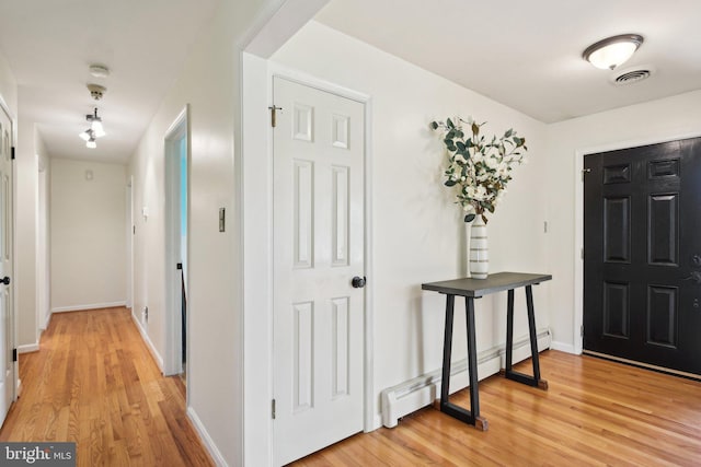 entryway with baseboard heating, light wood finished floors, baseboards, and visible vents