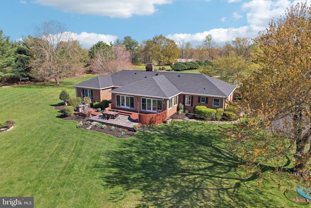 rear view of house with a patio area, brick siding, and a yard