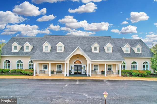 cape cod-style house with french doors and stucco siding
