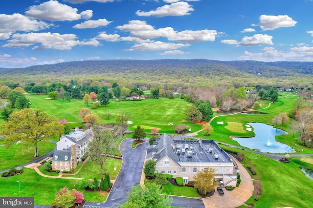 bird's eye view featuring a wooded view, view of golf course, and a water view