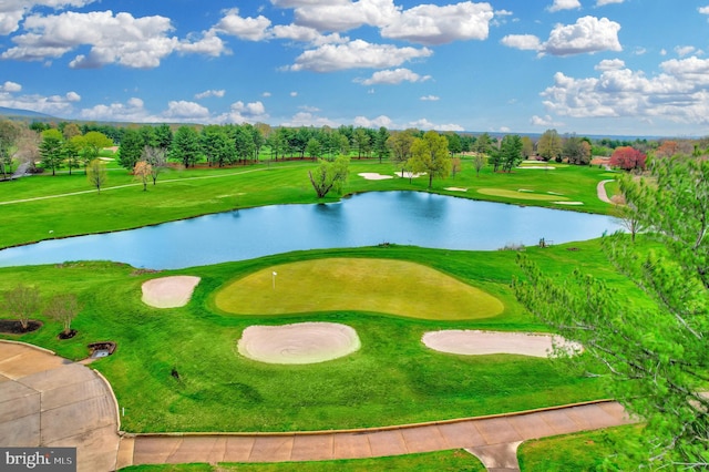 view of home's community featuring a lawn, view of golf course, and a water view
