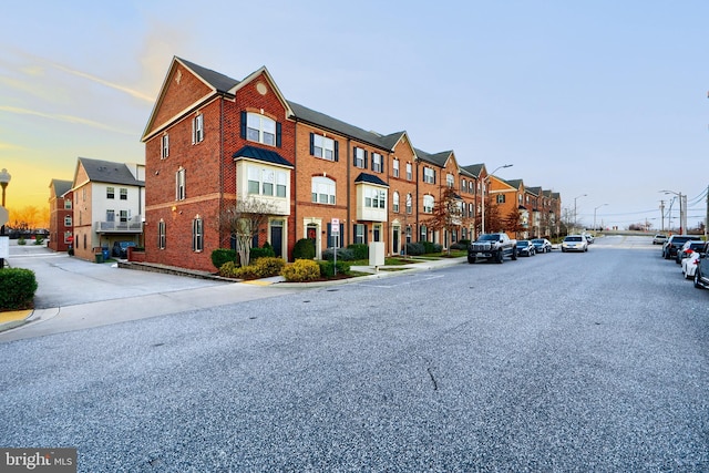 view of street with street lighting, a residential view, curbs, and sidewalks