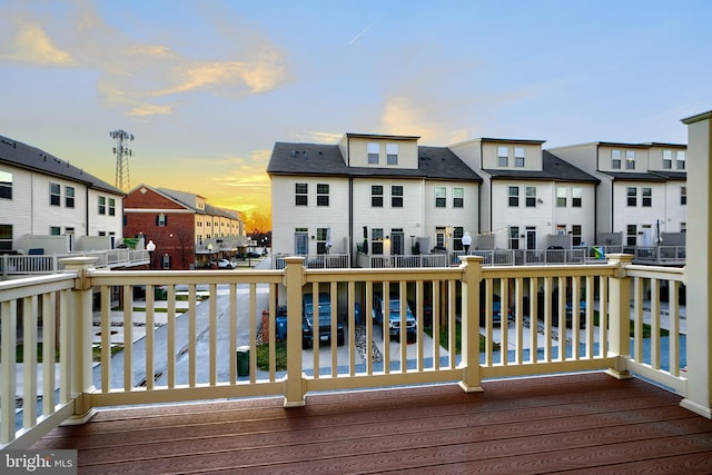 deck at dusk with a water view and a residential view