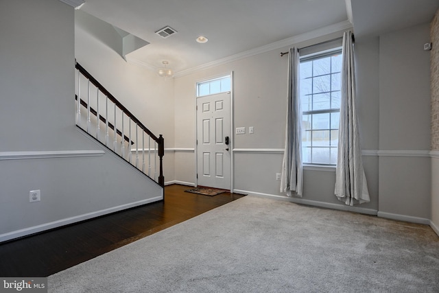 entryway featuring visible vents, baseboards, stairs, ornamental molding, and dark carpet