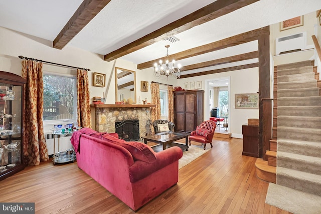 living room with hardwood / wood-style flooring, a fireplace, radiator heating unit, and stairs