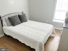 bedroom with wood finished floors and baseboards