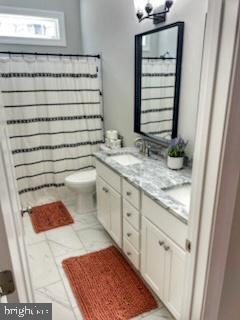 bathroom featuring tile patterned flooring, a shower with shower curtain, vanity, and toilet