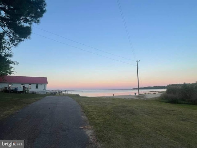 view of road featuring aphalt driveway and a water view