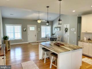 kitchen with light wood finished floors, a center island, white cabinetry, and a healthy amount of sunlight