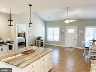 kitchen with pendant lighting, a wealth of natural light, white cabinetry, and light wood-style floors