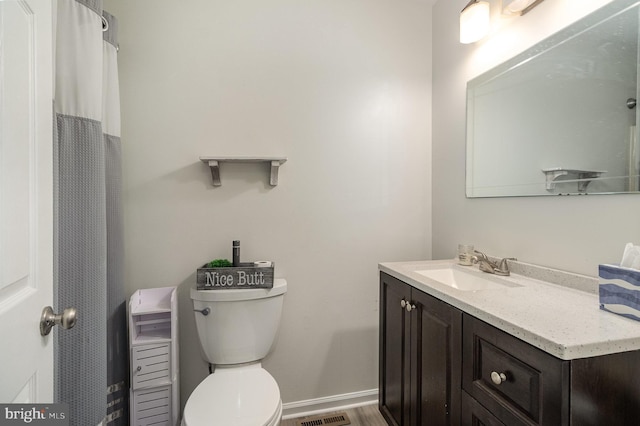 full bathroom with vanity, toilet, and baseboards