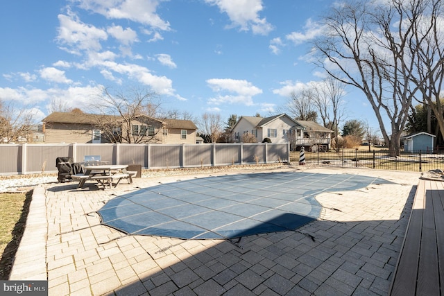 view of swimming pool featuring a patio area, a residential view, a fenced in pool, and a fenced backyard