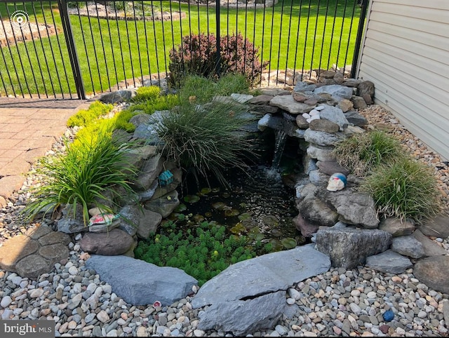 exterior details with fence and a small pond