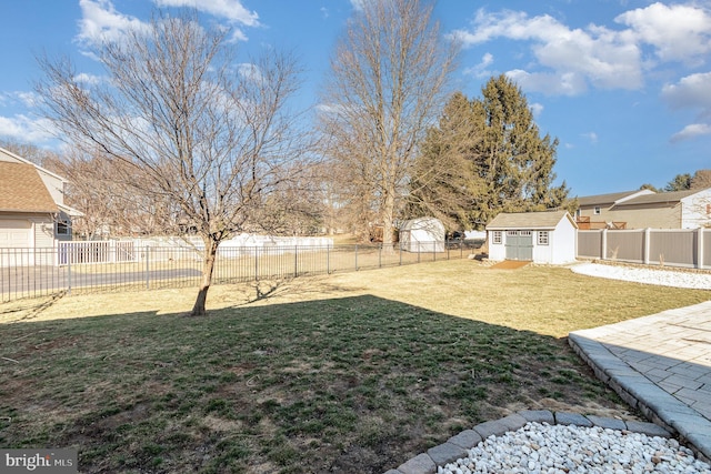 view of yard with an outbuilding, a storage unit, and a fenced backyard