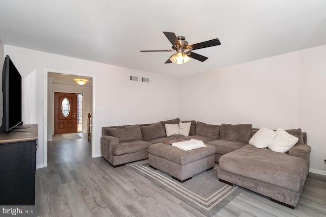 living room with light wood-style floors, baseboards, and ceiling fan